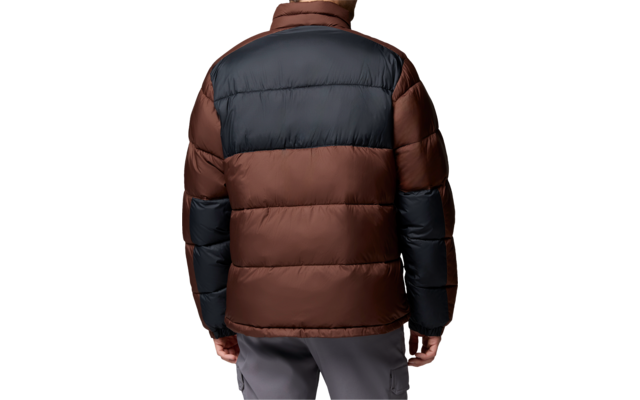 Person von hinten in braun-schwarzer Steppjacke, graue Hose, kurze dunkle Haare