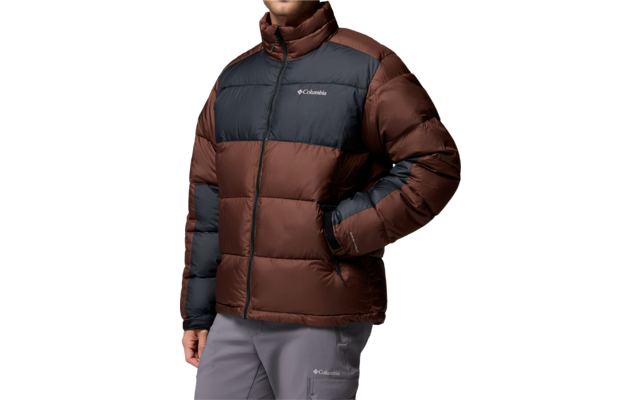 Person mit braun-dunkelgrauer Steppjacke, rechte Hand in Tasche, graue Hose, weißer Hintergrund