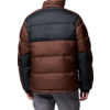 Person von hinten in braun-schwarzer Steppjacke, graue Hose, kurze dunkle Haare