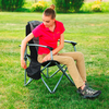 Garçon assis sur une chaise de camping en plein air