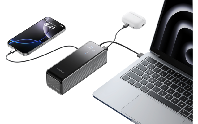 Laptop mit angeschlossenem Ladekabel, Powerbank lädt Kopfhörer und Smartphone