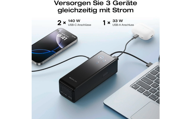 Drei elektronische Geräte werden gleichzeitig über ein schwarzes Ladegerät mit Kabeln an eine Laptop Tastatur angeschlossen