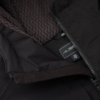Nahaufnahme einer schwarzen Jacke mit teilweise geöffnetem Reißverschluss, braunem gestricktem Futter, Klettverschluss und Innenetikett