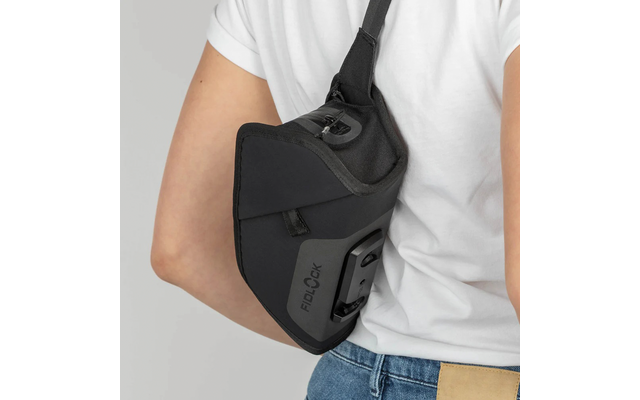 Person von hinten in weißem T‑Shirt und Jeans, trägt schwarze Umhänge-/Schultertasche mit sichtbarem FIDLOCK‑Logo und Clip