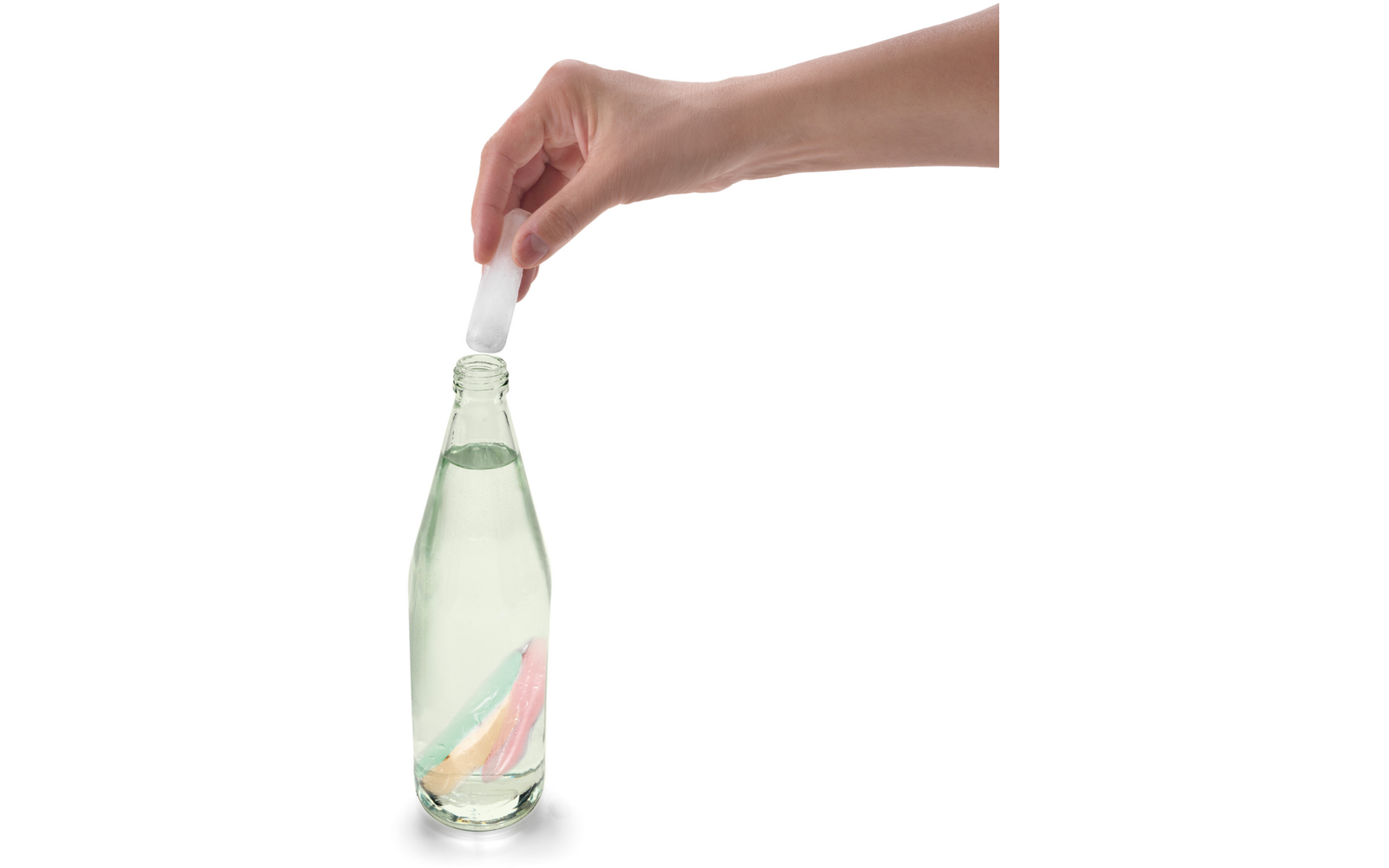 Hand hält einen Glasflaschenverschluss über einer geöffneten Glasflasche mit klarer Flüssigkeit
