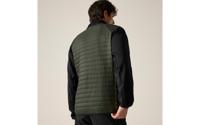 Person von hinten, trägt Jacke mit gesteppter olivgrüner Rückenpartie und schwarzen Ärmeln, heller einfarbiger Hintergrund