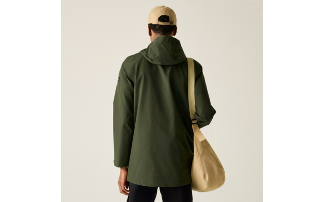 Person von hinten, olivgrüne Kapuzenjacke, beige Kappe, beige Umhängetasche, schwarze Hose, einfarbiger heller Hintergrund