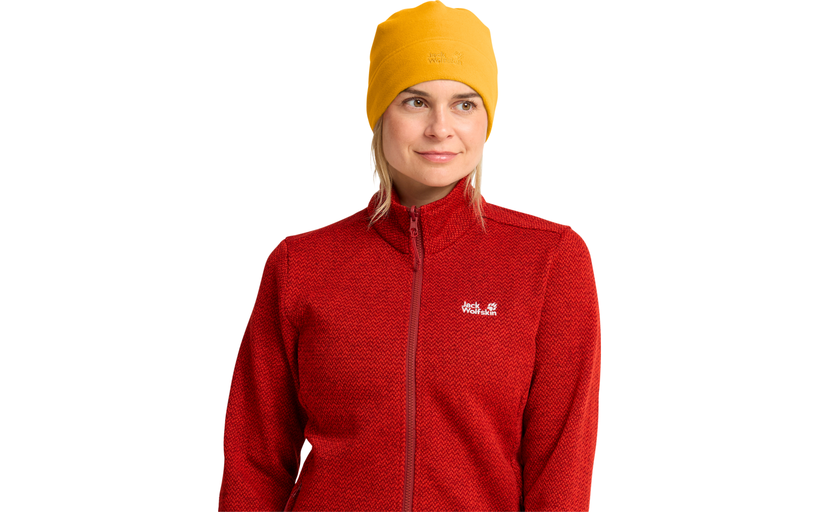 Frau mit gelber Mütze und roter Jacke mit Reißverschluss und weißem Logo, Blick nach rechts