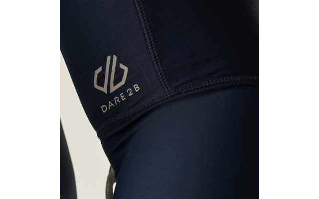 Plano detalle de tejido elástico azul oscuro con costuras visibles y el logotipo blanco 'DARE2B'