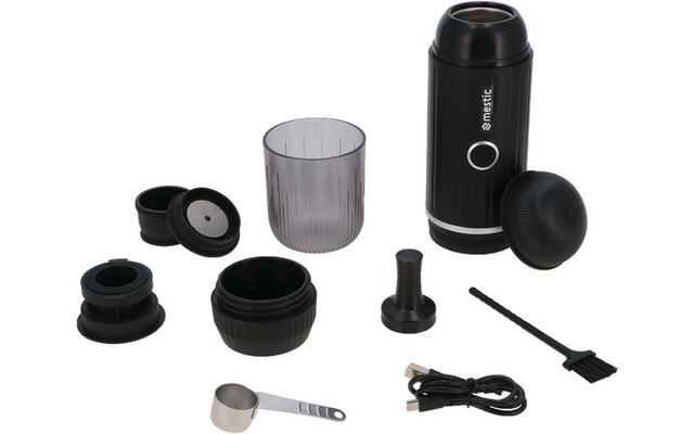 Schwarzes zylindrisches Gerät mit verschiedenen losen Zubehörteilen: transparenter Plastikbecher, mehrere runde schwarze Deckel und Ringe, kleiner Metallmesslöffel, schwarzes USB-Kabel und kleine Reinigungsbürste auf weißem Hintergrund