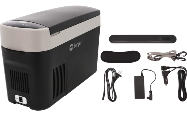 Grau-schwarze rechteckige Box mit geschlossenem Deckel und Logo, daneben zwei schwarze Schaumstoffstücke und mehrere Kabel mit Netzteil und Auto-Stecker