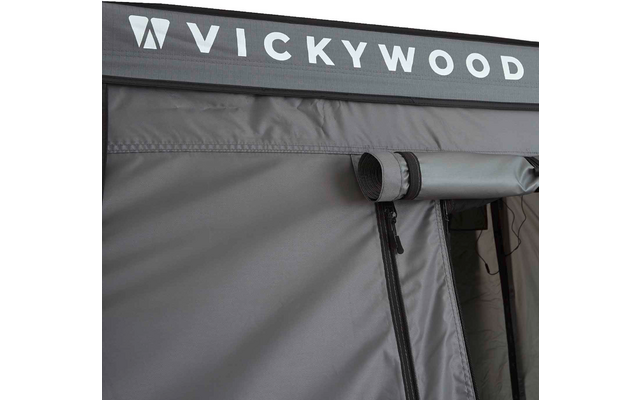 Grau-schwarze Stoffwand mit weißer Aufschrift 'VICKYWOOD', eingerollter Fensterklappe und sichtbarem Reißverschluss