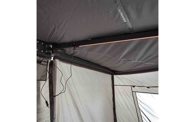 Innenansicht eines grauen Zelts mit sichtbarem Metallgestänge, LED-Lichtleiste an der Deckenstange und hängendem Kabel mit Stecker