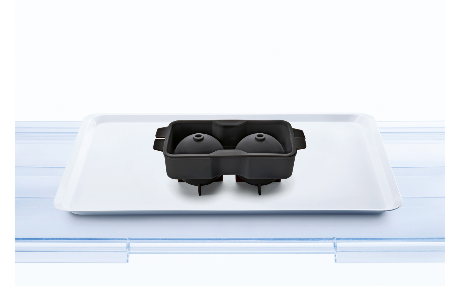 Schwarze VR-Brille auf weißem Tablett auf hellblauem Hintergrund