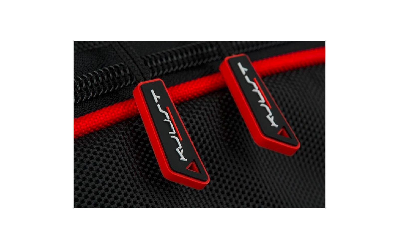 Gros plan de deux curseurs de fermeture éclair rouges avec insert noir et marquages blancs sur tissu noir texturé, à côté d'une bande de fermeture éclair rouge