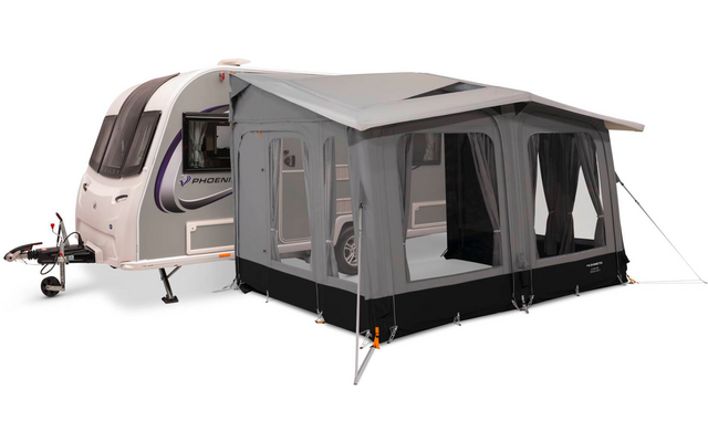 Weißer Wohnwagen mit angebautem grauem Vorzelt, sichtbare Fenster mit Vorhängen, Abspannleinen und Stützstangen; Anhängerkupplung vorne sichtbar