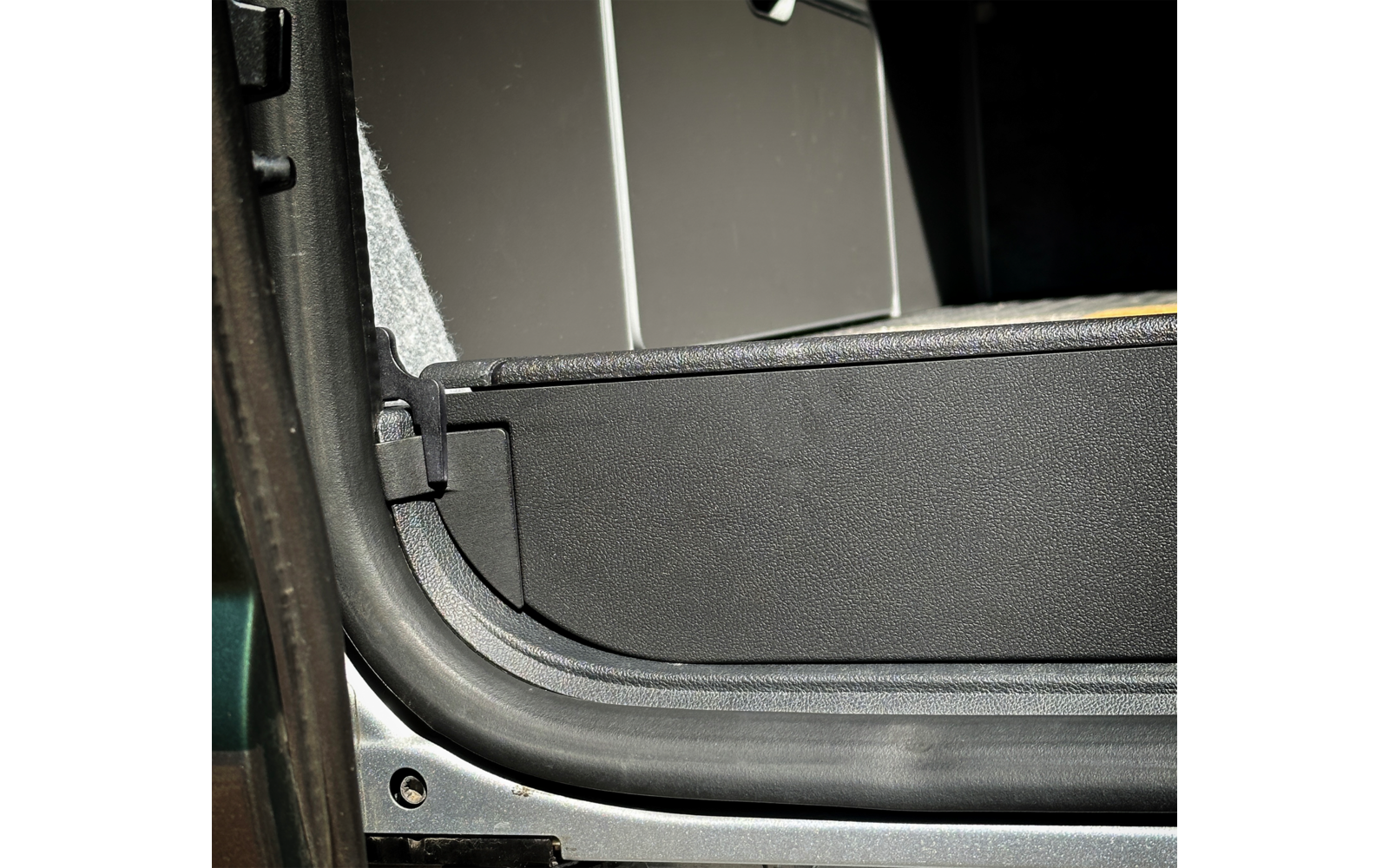 Nahaufnahme eines geöffneten Autotürbereichs mit sichtbarem Türrahmen und Innenraum