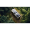 Wohnmobil mit Solarpanelen auf dem Dach fährt auf einem Waldweg