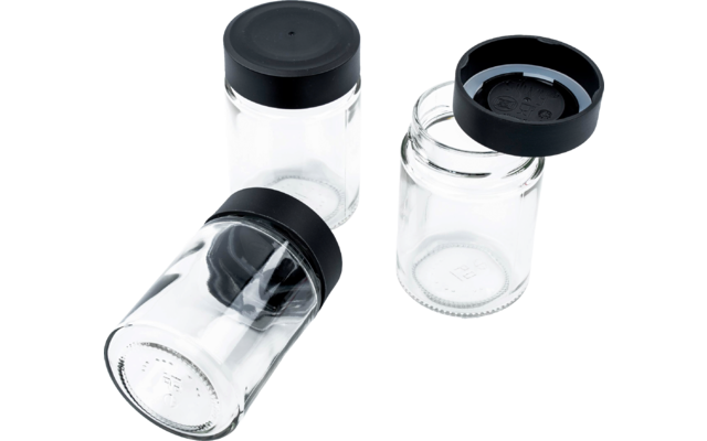 Drei transparente Glasbehälter mit schwarzen Deckeln; eines liegt auf der Seite, eines steht mit Deckel, eines steht offen mit Deckel daneben