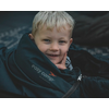 Junge mit blondem Haar, der in einem Schlafsack liegt und in die Kamera lächelt