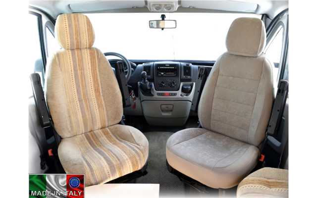 View inside the driver's cabin of a vehicle with two front seats, a steering wheel, and a dashboard