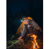 Mann zündet am Lagerfeuer eine Fackel an, Nacht im Wald