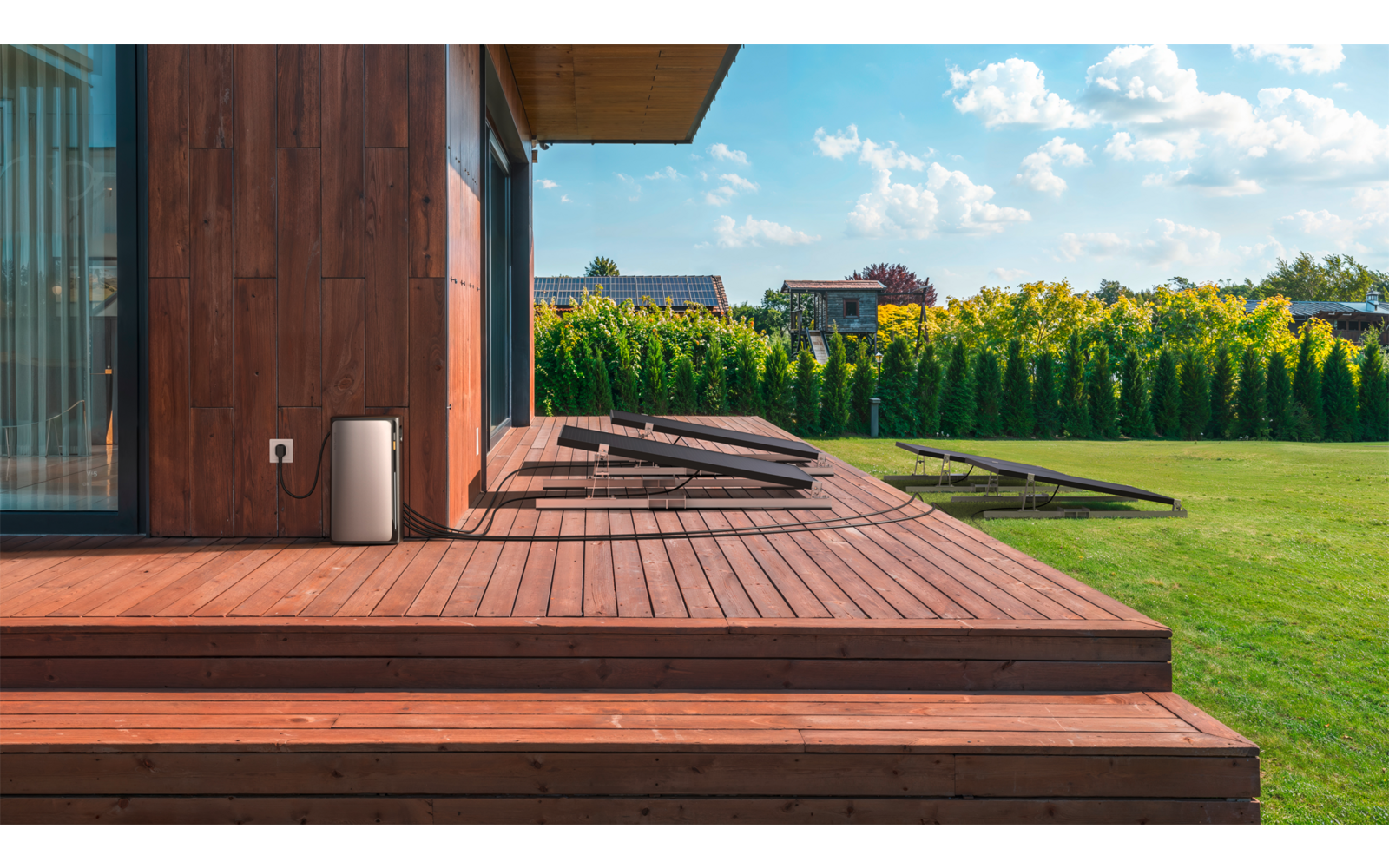 Holzterrasse mit Stufen vor einem Haus und Rasenfläche