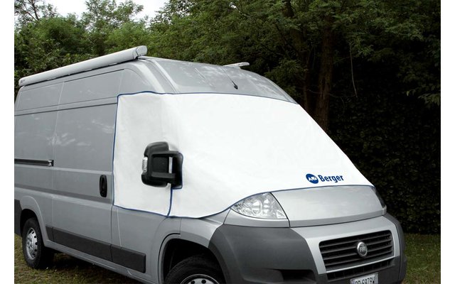 witte bestelwagen met een hoes over de voorruit, bomen op de achtergrond