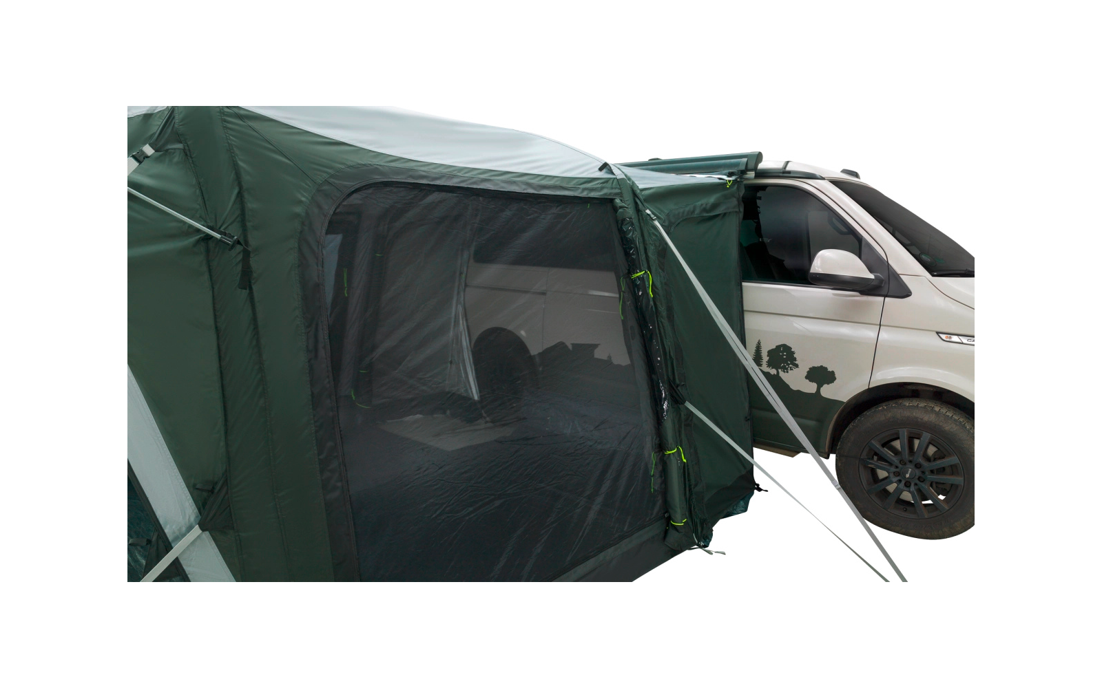 Grünes Vorzelt mit Moskitonetz und Reißverschluss, an der Seite eines weißen Campingbusses befestigt; vorderes Rad und Baumaufkleber sichtbar