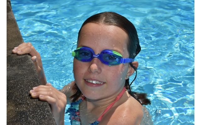 Person mit nassen Haaren und blauen Schwimmbrillen im Wasser
