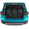 Coffre ouvert d'une voiture turquoise contenant trois sacs à dos noirs côte à côte