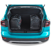 Coffre ouvert d'une voiture turquoise avec deux sacs à dos noirs à l'intérieur