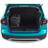 Coffre ouvert d'une voiture turquoise avec un sac à dos noir à accents rouges sur le côté gauche