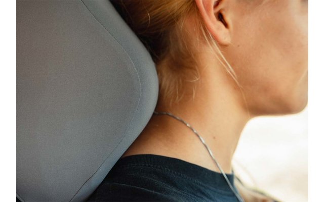 Side view of a person's neck with hair tied up, silver necklace, ear, black top and gray car headrest