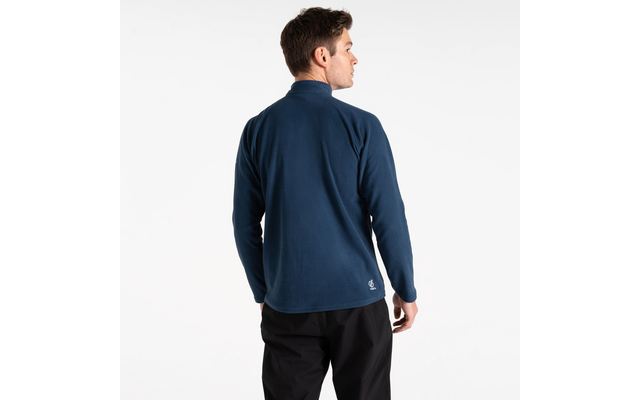 Mann steht mit dem Rücken zur Kamera und trägt eine blaue Jacke und schwarze Hose