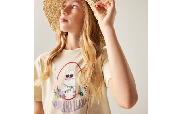 Person mit Strohhut, langem blondem Haar, helles T-Shirt mit Lama-Illustration und Schriftzug "NO DRAMA LLAMA", blickt nach oben links, hält den Hutrand