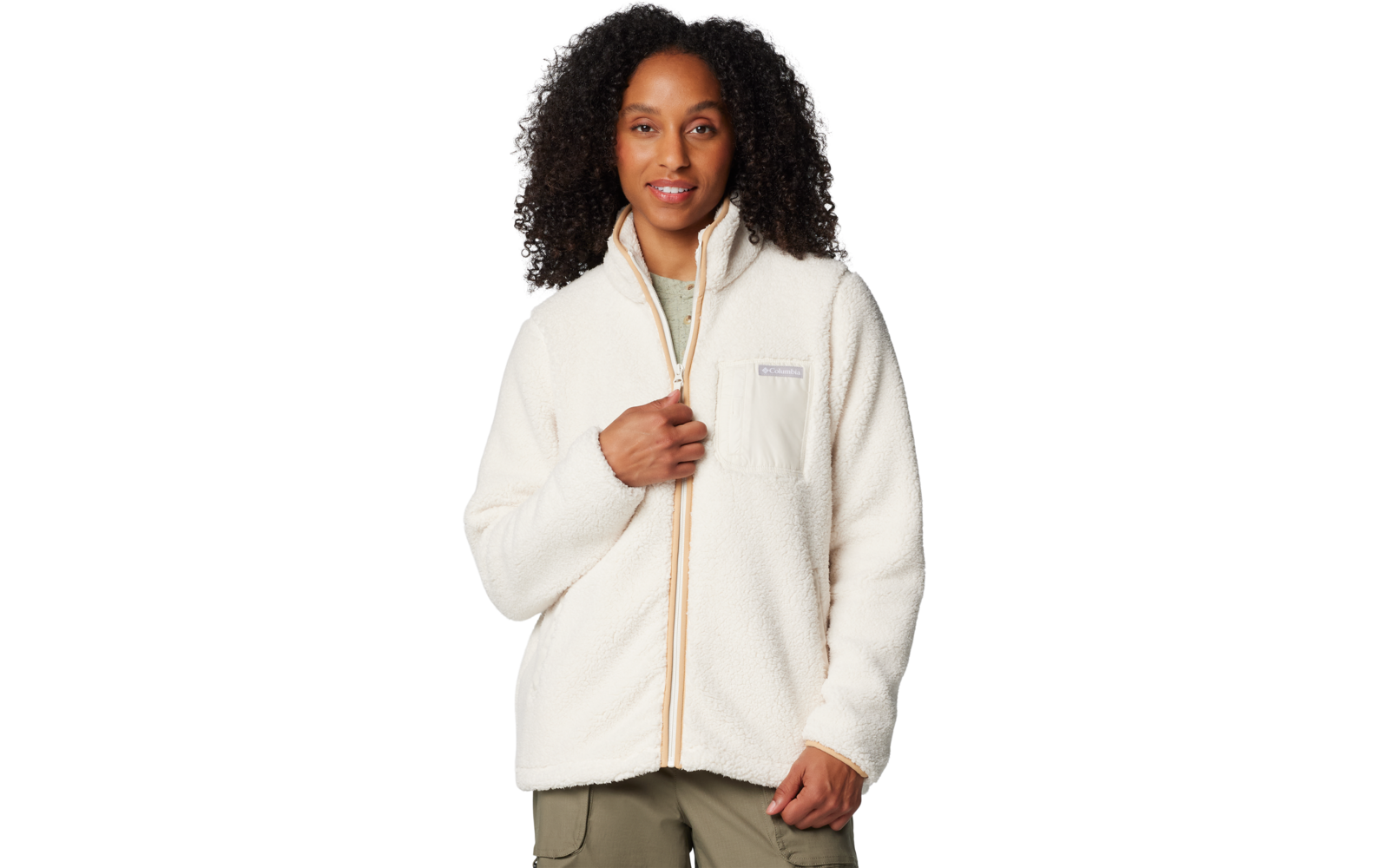 Person mit dichtem, lockigem, dunklem Haar trägt eine weiße Fleecejacke mit Reißverschluss, eine Hand hält den Reißverschluss, vor weißem Hintergrund