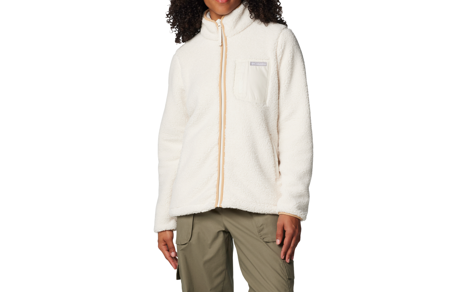 Personne aux cheveux bouclés portant une veste polaire crème à fermeture éclair complète et poche poitrine, pantalon vert olive, sur fond blanc