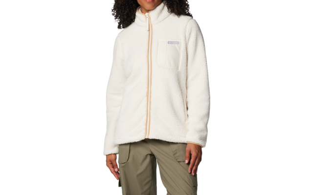 Personne aux cheveux bouclés portant une veste polaire crème à fermeture éclair complète et poche poitrine, pantalon vert olive, sur fond blanc