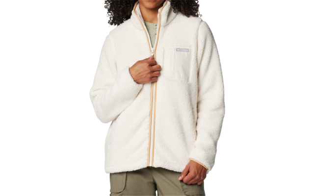 Personne aux cheveux épais et bouclés, portant une veste polaire blanche zippée, une main tient la fermeture éclair, sur fond blanc