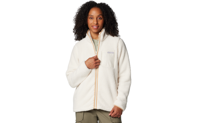 Person mit dichtem, lockigem, dunklem Haar trägt eine weiße Fleecejacke mit Reißverschluss, eine Hand hält den Reißverschluss, vor weißem Hintergrund