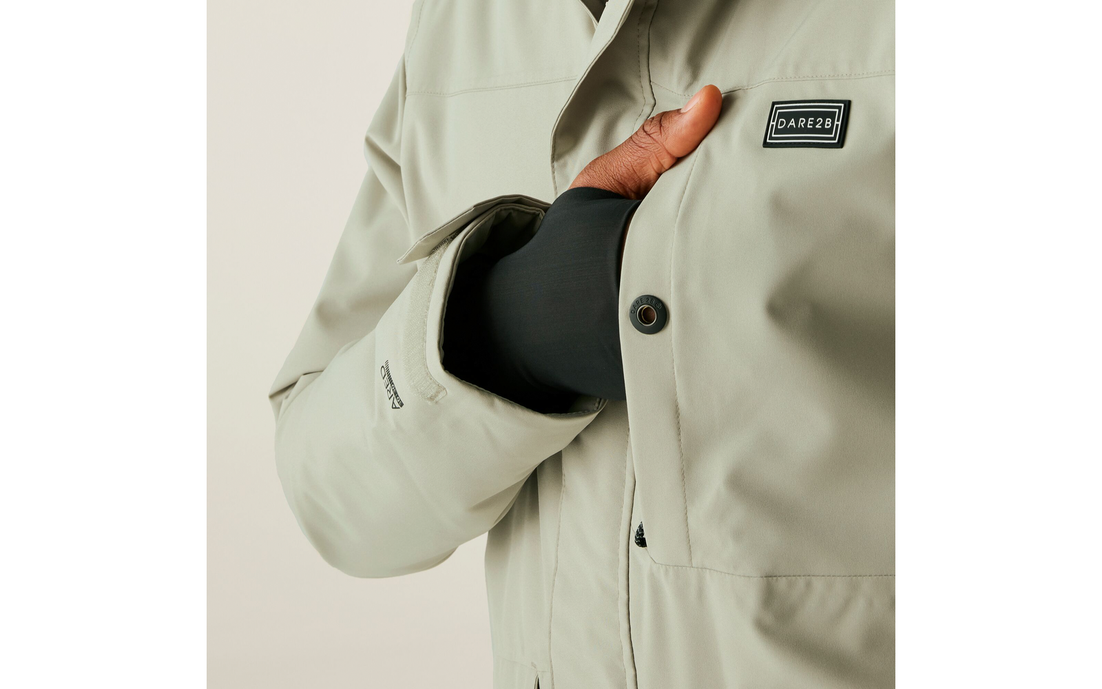 Person trägt eine helle Jacke, Hand in der Brusttasche