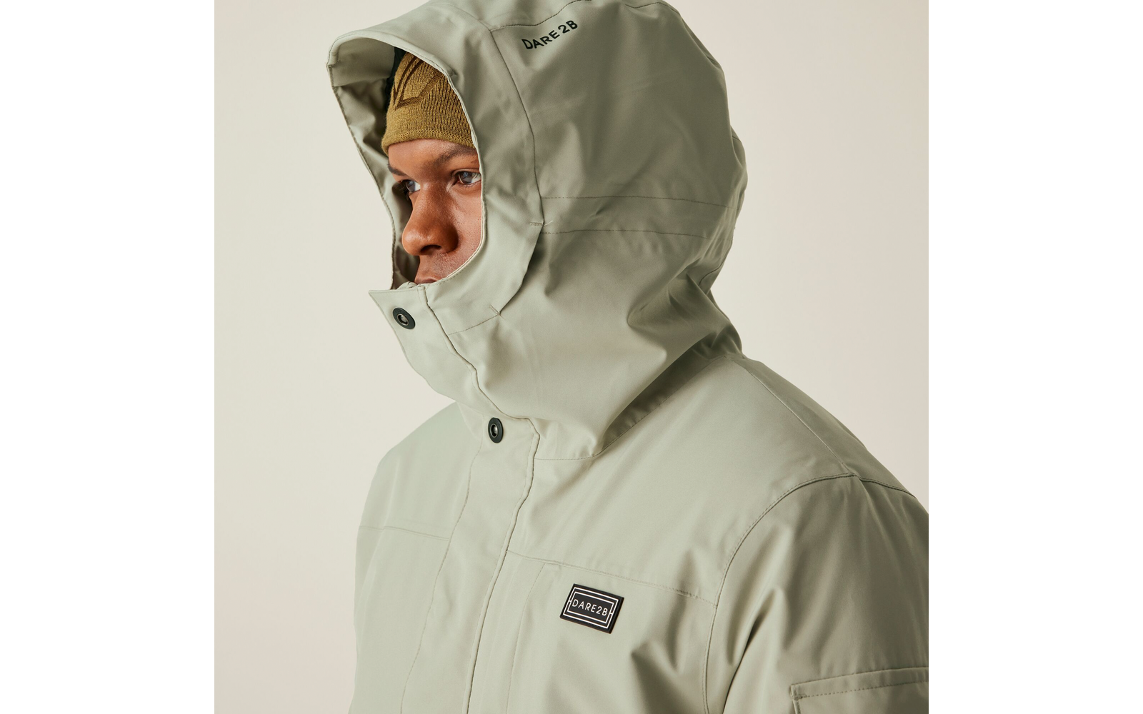 Person trägt eine helle Kapuzenjacke mit Reißverschluss und Knöpfen