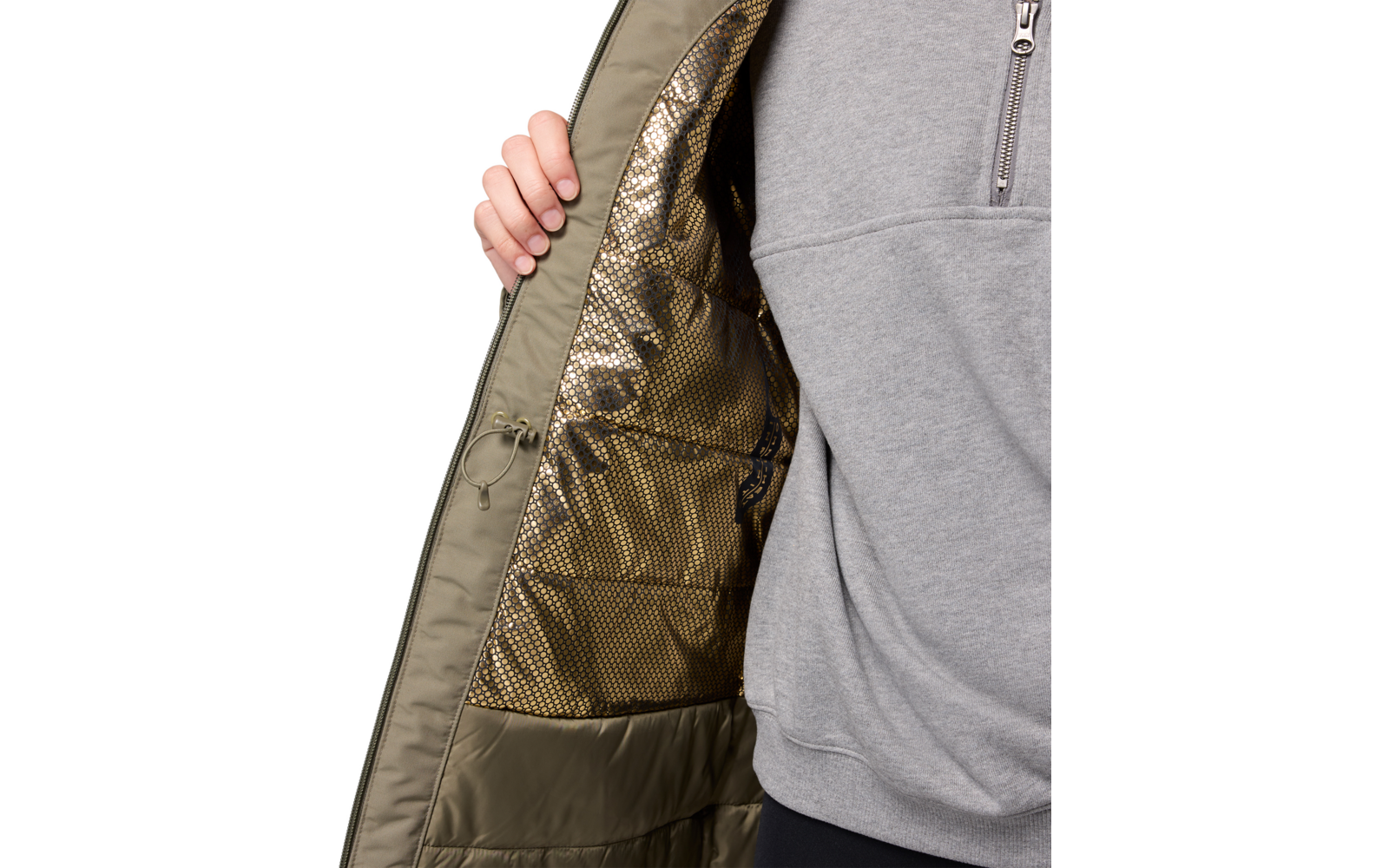 Person öffnet die Innenseite einer grünen Jacke, trägt graues Oberteil