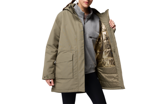 Homme portant une longue veste beige, ouverte, avec un sweat gris et un pantalon noir en dessous