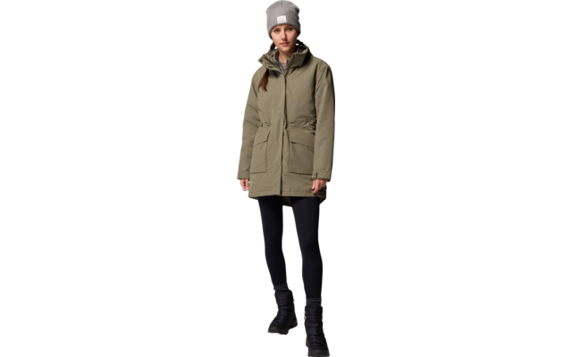 Femme porte une veste verte, un pantalon noir et un bonnet gris