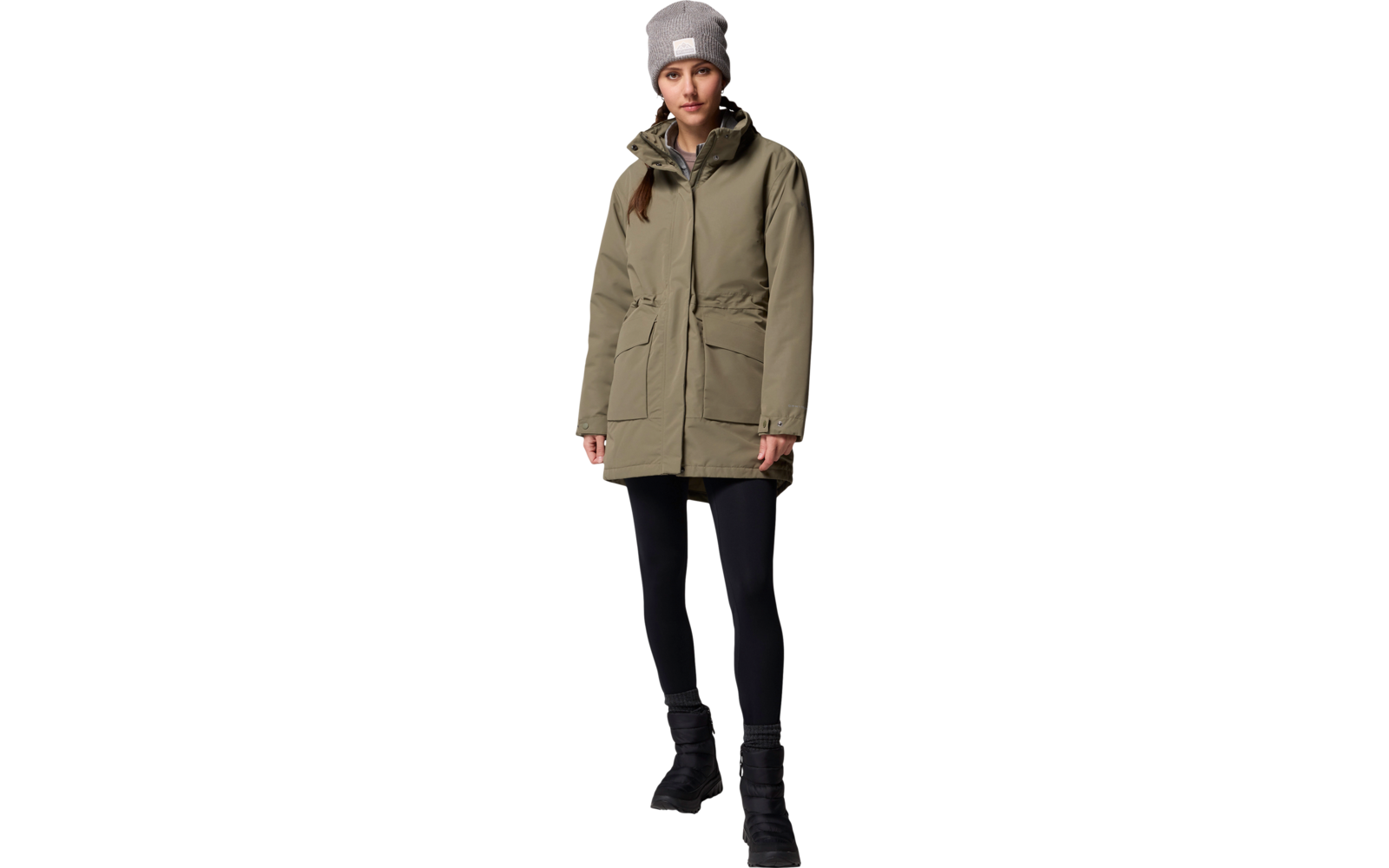 Femme porte une veste verte, un pantalon noir et un bonnet gris
