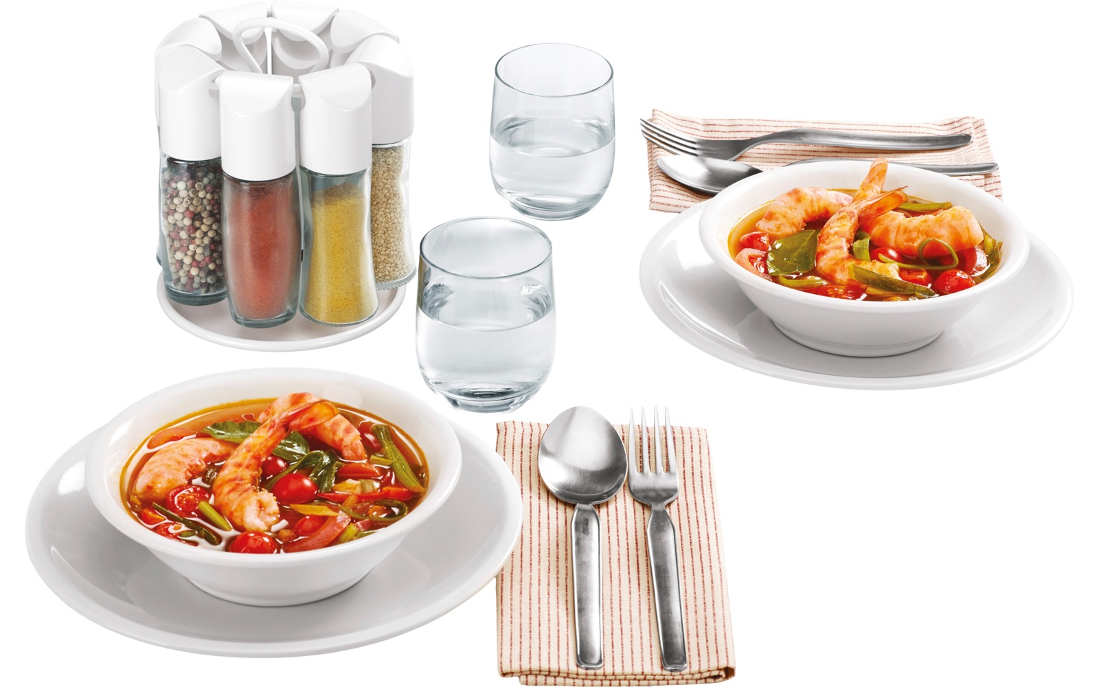 Zwei Teller mit Gemüsesuppe, zwei Gläser Wasser, Besteck auf Stoffserviette und Gewürzstreuer auf weißem Tisch