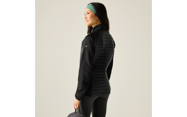 Persoon zijwaarts, kijkt naar links, zwarte doorgestikte jas, zwarte legging, groen haarband, houdt een donkere ronde tas vast, lichte achtergrond