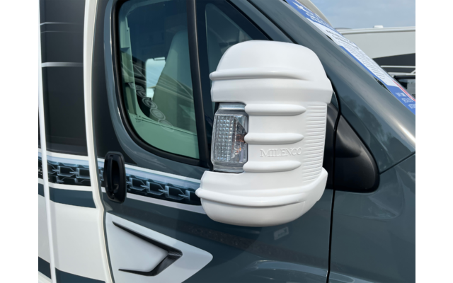 Rétroviseur avec coque blanche et clignotant intégré sur un véhicule gris; vitre et poignée de porte visibles